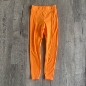 Alo Yoga High Waist 7/8 leggings in Neon Apricot from the NO LIMITS collection.
